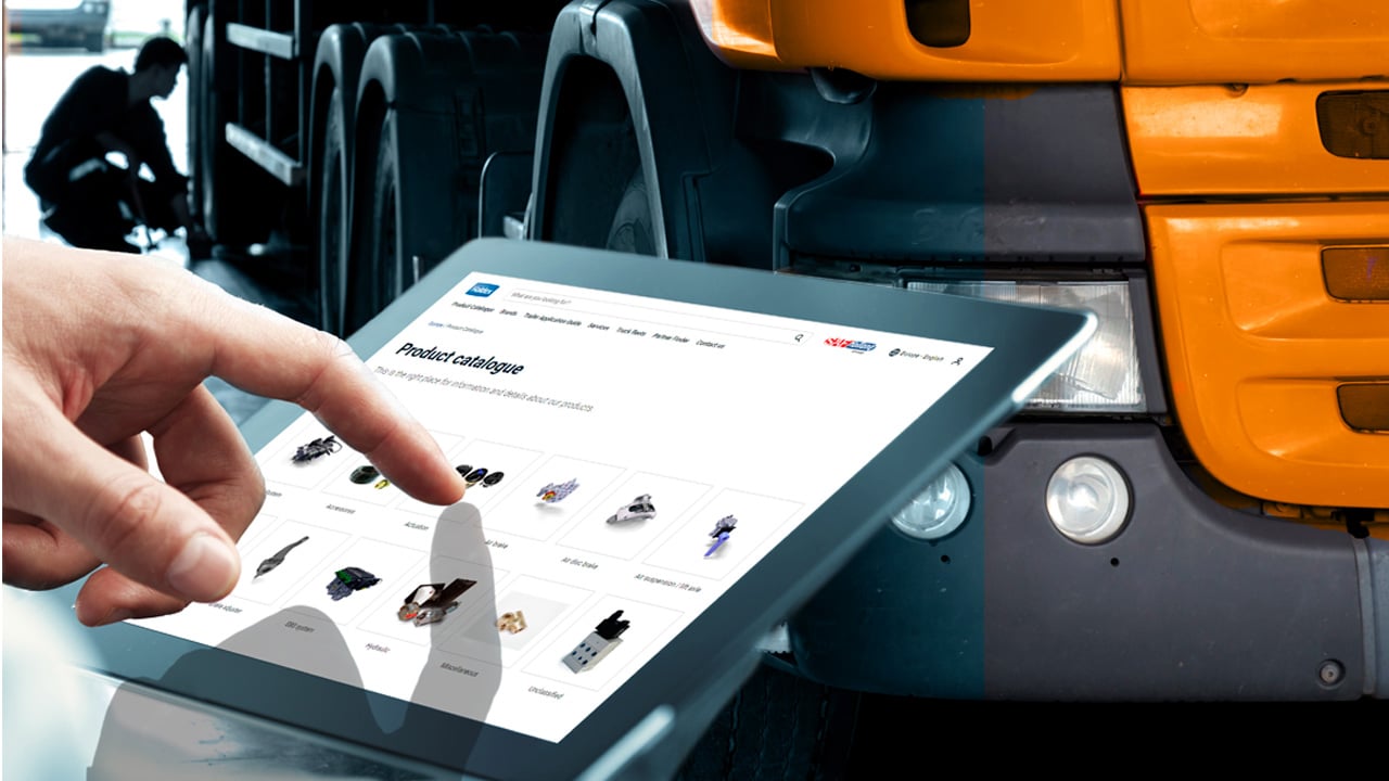 A hand navigates a digital product catalog on a tablet in front of a truck