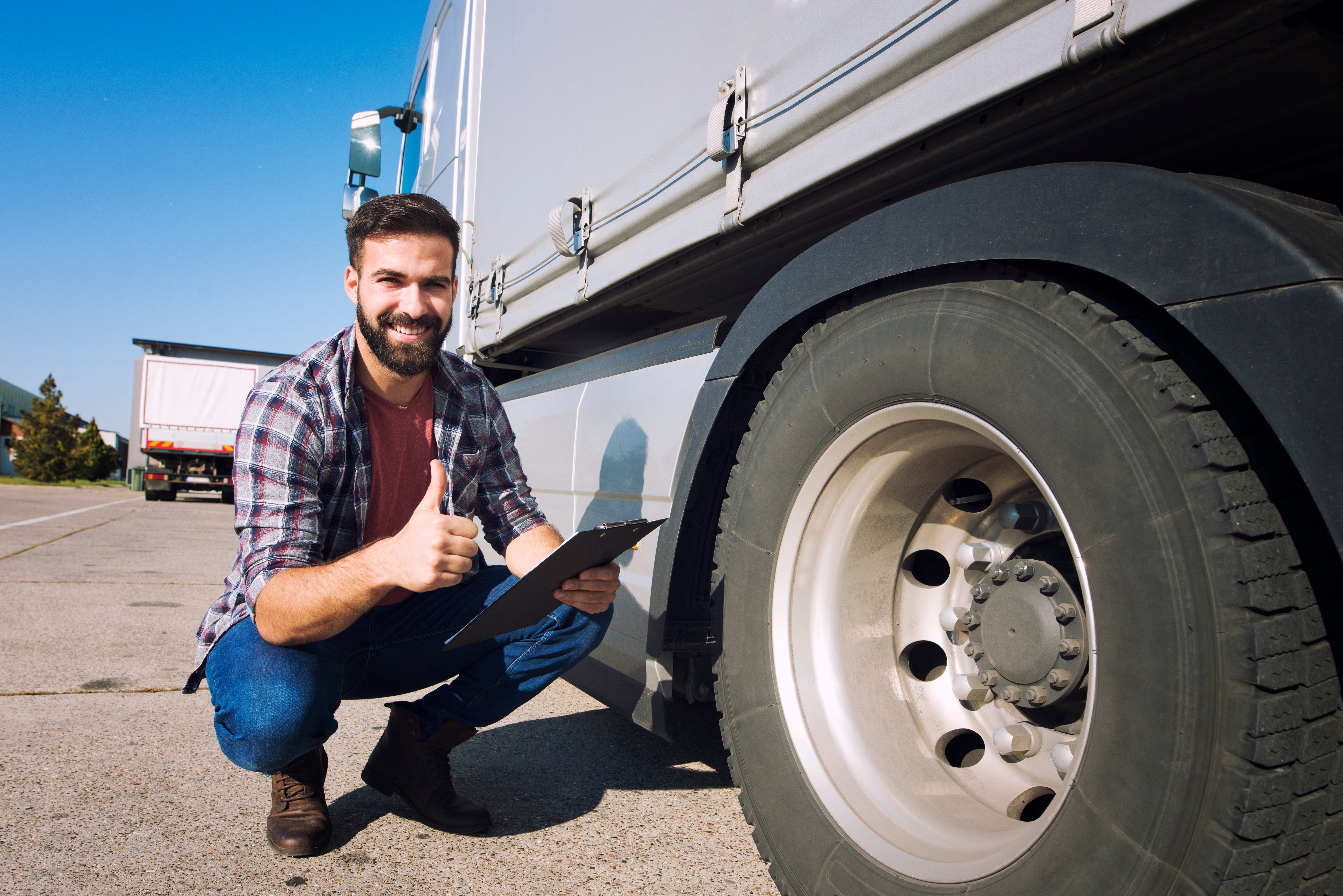 A person kneeling next to a truck